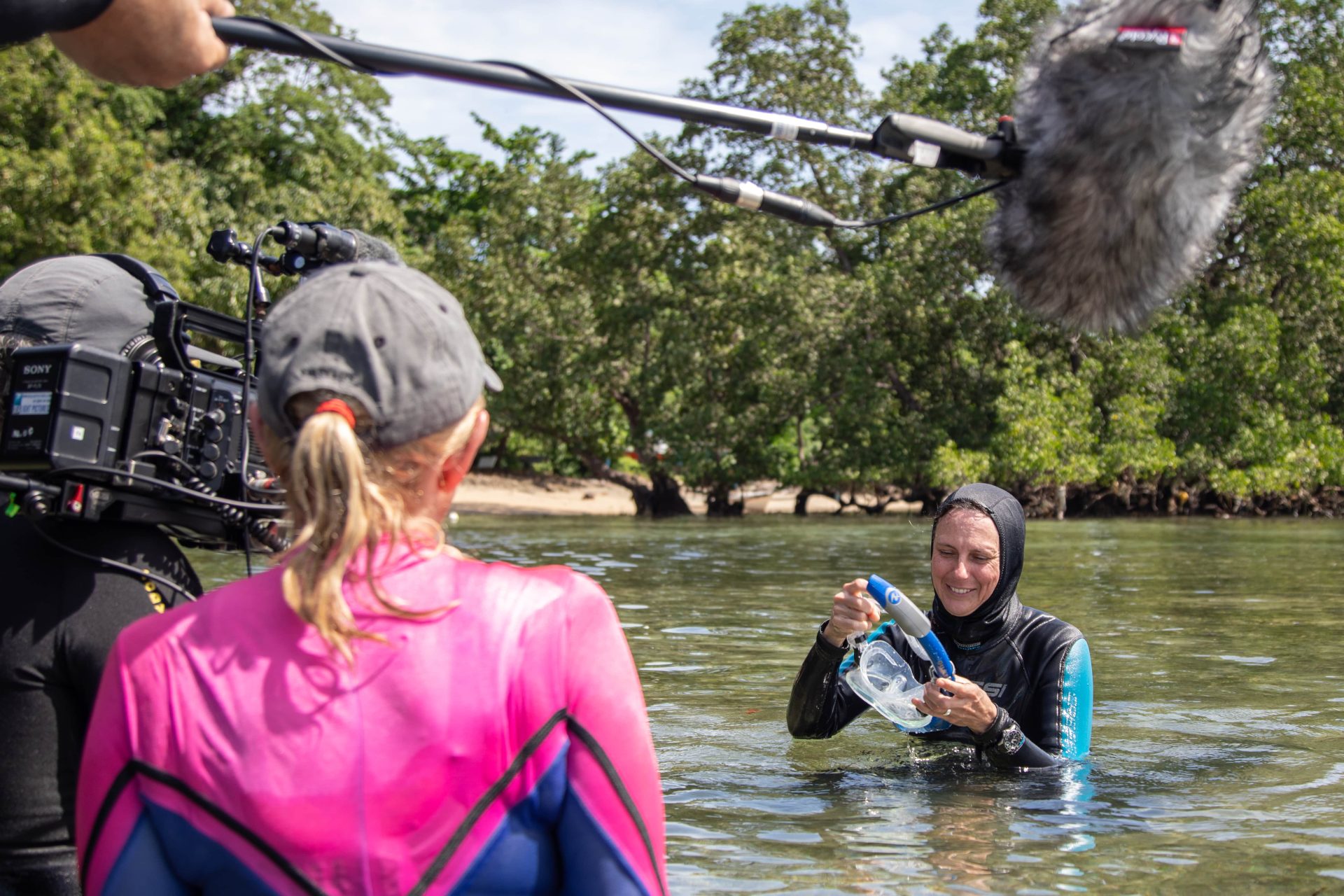 SeaLight Pictures' Colette Beaudry half in half out of the water, Indonesia, with the Aussie Secrets of the Octopus film team and Algae Octopus scientist Dr Chrissy Huffard.